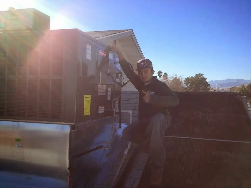 HVAC technician performing Air Duct Cleaning on a rooftop unit in Frederick